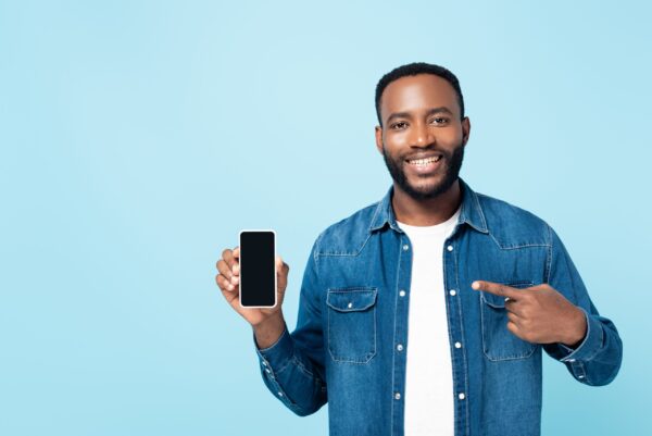 Cheerful,African,American,Man,Pointing,At,Smartphone,With,Blank,Screen