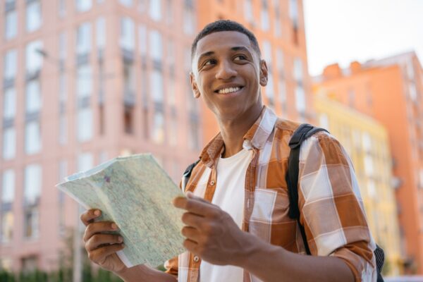 Handsome,Smiling,African,American,Man,Tourist,Holding,Travel,Map,,Searching