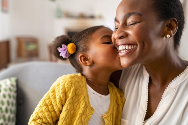 Close,Up,Of,Beautiful,Daughter,Kissing,Mother,On,Cheek,At